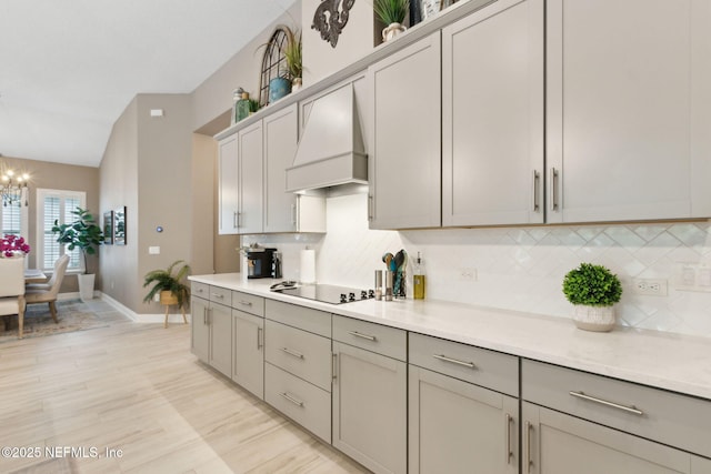 95196 Golden Glow Dr, Fernandina Beach, FL 32034 - kitchen featuring custom exhaust hood, black electric stovetop, gray cabinetry, backsplash, and a chandelier