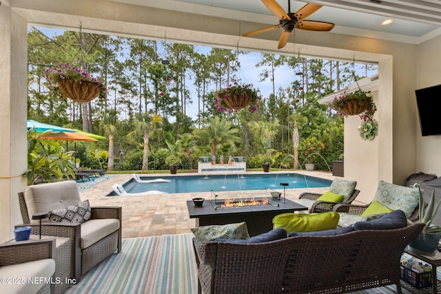 95196 Golden Glow Dr, Fernandina Beach, FL 32034 - outdoor pool with ceiling fan, an outdoor living space with a fire pit, a patio area, and view of wooded area