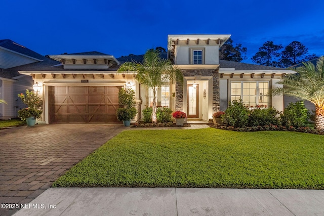95196 Golden Glow Dr, Fernandina Beach, FL 32034 - mediterranean / spanish house with an attached garage, decorative driveway, a lawn, stucco siding, and stone siding