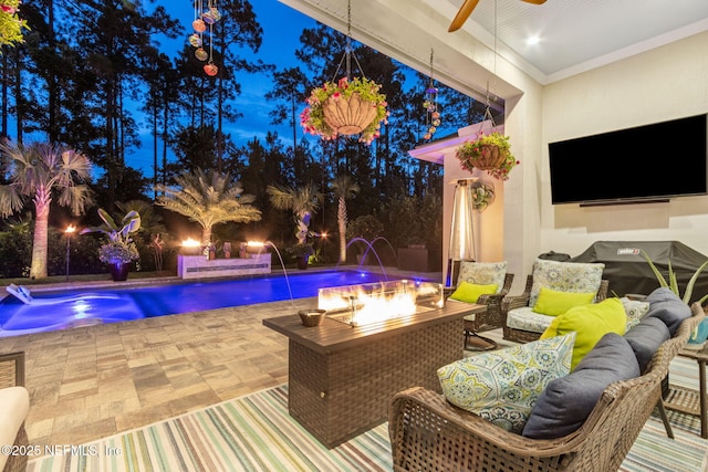 95196 Golden Glow Dr, Fernandina Beach, FL 32034 - pool at night with an outdoor living space with a fire pit, a patio area, a ceiling fan, and an outdoor pool