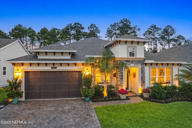 95196 Golden Glow Dr, Fernandina Beach, FL 32034 - view of front facade with a garage, stucco siding, stone siding, decorative driveway, and a lawn
