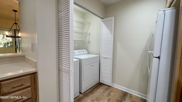 2664 SW 14th Dr Unit 325, Gainesville, FL 32608 - laundry area featuring wood finished floors, a chandelier, and washer and dryer