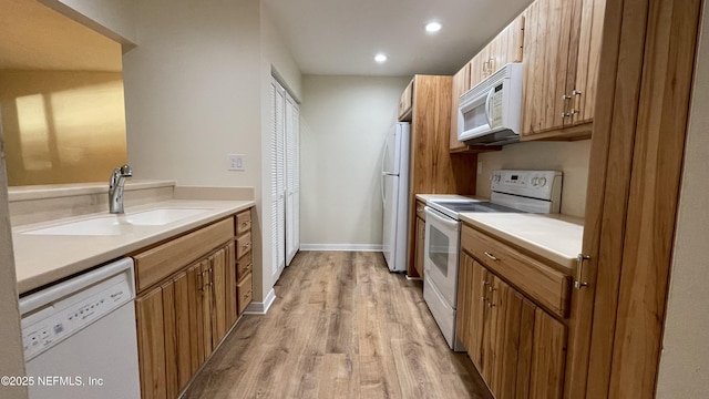 2664 SW 14th Dr Unit 325, Gainesville, FL 32608 - kitchen featuring white appliances, light wood finished floors, light countertops, recessed lighting, and brown cabinetry