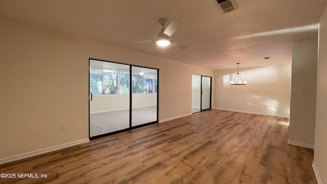 2664 SW 14th Dr Unit 325, Gainesville, FL 32608 - unfurnished room with a chandelier, wood finished floors, and a ceiling fan