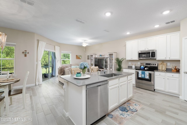 30 Yeti Ct, Saint Augustine, FL 32092 - kitchen with stainless steel appliances, light wood finished floors, open floor plan, white cabinetry, and a ceiling fan