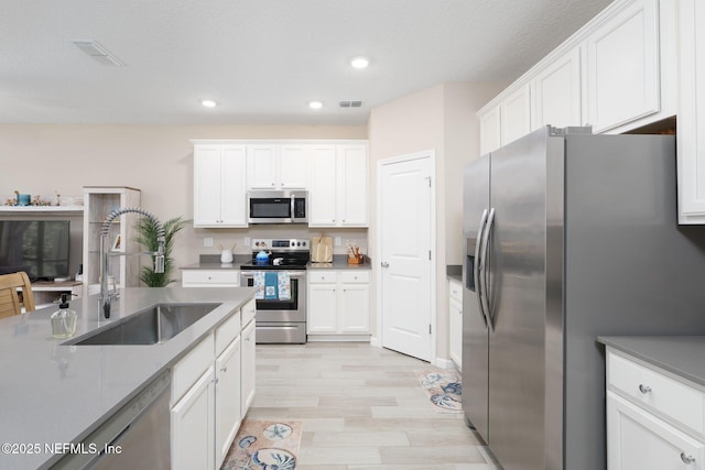 30 Yeti Ct, Saint Augustine, FL 32092 - kitchen featuring stainless steel appliances, white cabinetry, light wood finished floors, and recessed lighting