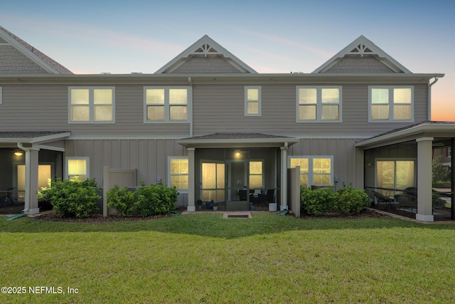 30 Yeti Ct, Saint Augustine, FL 32092 - back of property with a sunroom, a lawn, and board and batten siding
