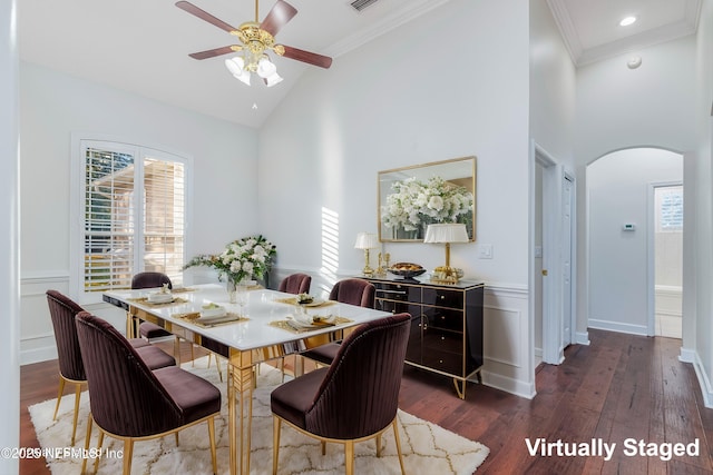 1700 Southcreek Dr, Saint Johns, FL 32259 - dining space with arched walkways, dark wood-style floors, ceiling fan, high vaulted ceiling, and a wainscoted wall