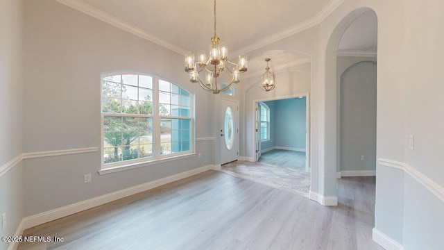 99 Sloganeer Trl, Palm Coast, FL 32164 - entryway with wood finished floors, a chandelier, ornamental molding, and arched walkways