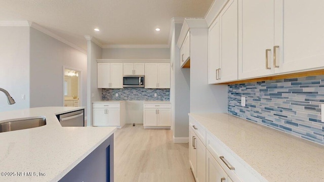 99 Sloganeer Trl, Palm Coast, FL 32164 - kitchen with appliances with stainless steel finishes, tasteful backsplash, white cabinets, light stone counters, and ornamental molding