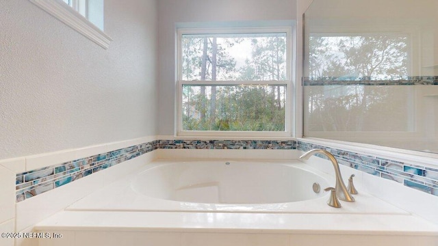 99 Sloganeer Trl, Palm Coast, FL 32164 - bathroom with plenty of natural light, a garden tub, and a textured wall