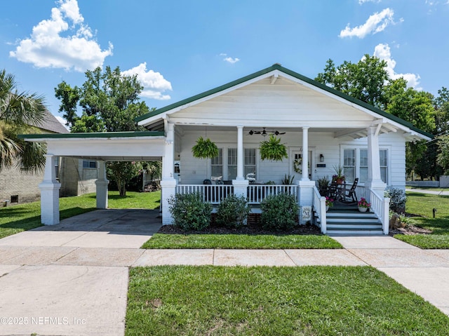 117 Parshley St SW, Live Oak, FL 32064 - view of front facade with covered porch, a front yard, concrete driveway, and a carport