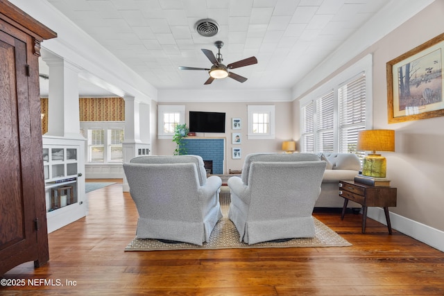 117 Parshley St SW, Live Oak, FL 32064 - living area with ceiling fan, hardwood / wood-style floors, ornate columns, and a fireplace