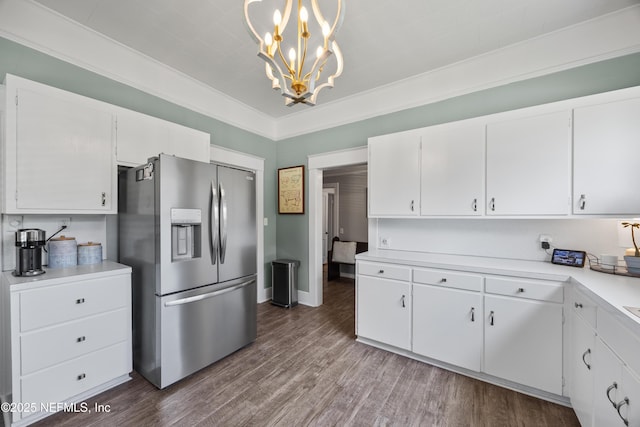 117 Parshley St SW, Live Oak, FL 32064 - kitchen featuring stainless steel refrigerator with ice dispenser, light countertops, white cabinetry, wood finished floors, and ornamental molding