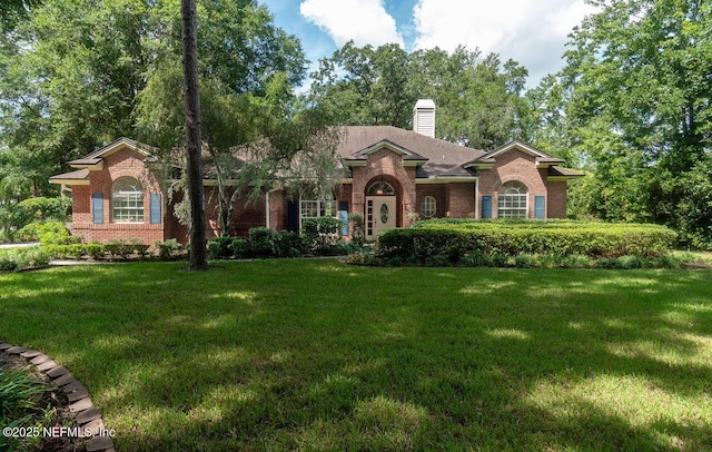 1877 Medinah Ln, Green Cove Springs, FL 32043 - view of front of home featuring brick siding, a chimney, and a front yard