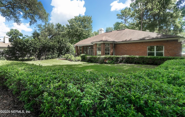 1877 Medinah Ln, Green Cove Springs, FL 32043 - back of property with brick siding, a chimney, a yard, and a sunroom