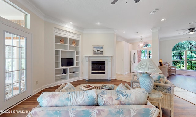 1877 Medinah Ln, Green Cove Springs, FL 32043 - living room featuring a ceiling fan, crown molding, a glass covered fireplace, built in features, and recessed lighting