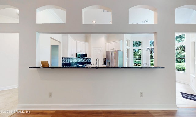 1877 Medinah Ln, Green Cove Springs, FL 32043 - kitchen with stainless steel appliances, dark stone countertops, white cabinets, decorative backsplash, and a peninsula