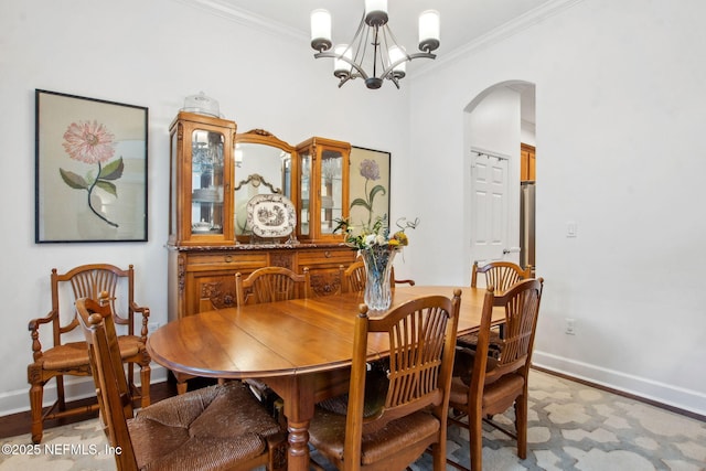 85488 Sagaponack Dr, Fernandina Beach, FL 32034 - dining area featuring arched walkways, a chandelier, and crown molding
