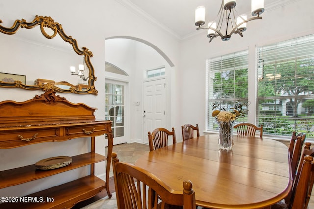 85488 Sagaponack Dr, Fernandina Beach, FL 32034 - dining room featuring arched walkways, a chandelier, ornamental molding, and vaulted ceiling