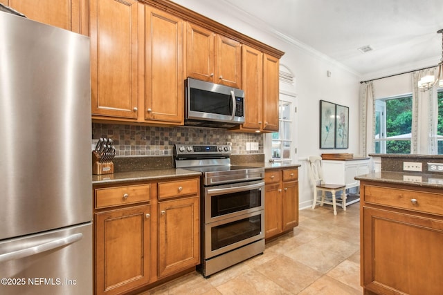 85488 Sagaponack Dr, Fernandina Beach, FL 32034 - kitchen with stainless steel appliances, brown cabinets, decorative backsplash, crown molding, and dark stone countertops