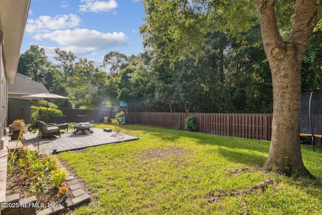 85488 Sagaponack Dr, Fernandina Beach, FL 32034 - fenced backyard featuring an outdoor fire pit, a trampoline, and a patio area