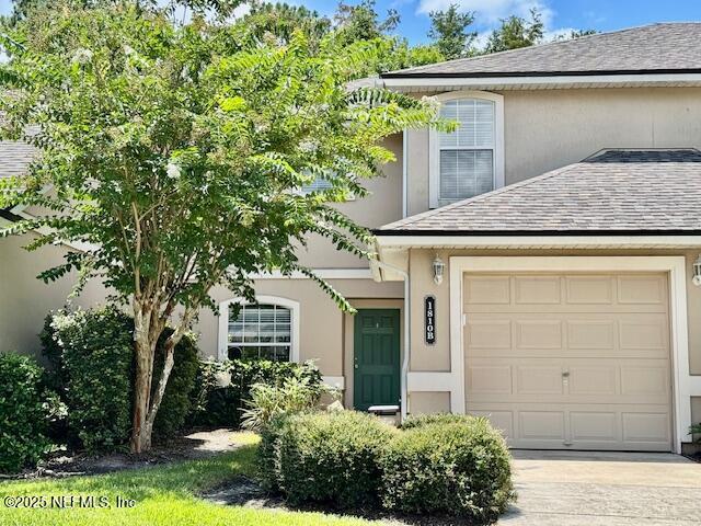 1810 Green Springs Cir Unit B, Fleming Island, FL 32003 - view of front of property featuring stucco siding, concrete driveway, roof with shingles, and an attached garage