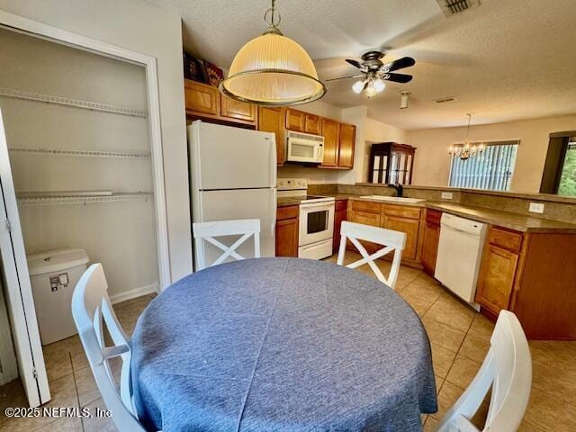 1810 Green Springs Cir Unit B, Fleming Island, FL 32003 - kitchen with white appliances, a peninsula, a chandelier, hanging light fixtures, and brown cabinetry