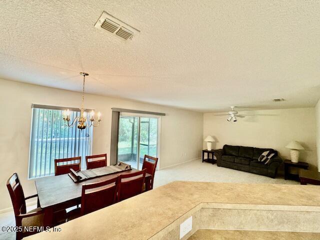 1810 Green Springs Cir Unit B, Fleming Island, FL 32003 - carpeted dining space with a chandelier, ceiling fan, and a textured ceiling