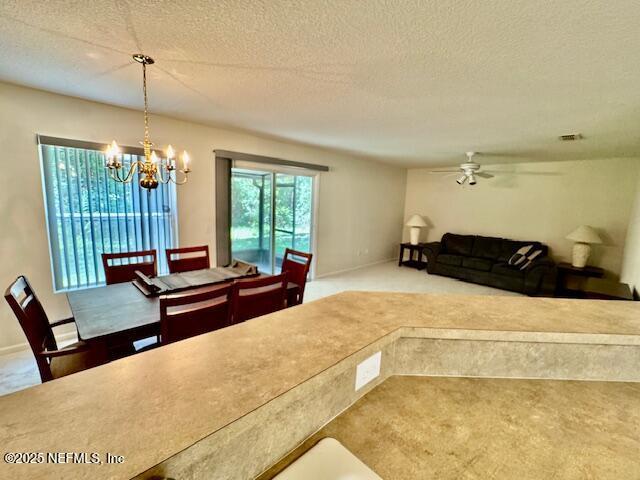 1810 Green Springs Cir Unit B, Fleming Island, FL 32003 - carpeted dining area with a chandelier, a ceiling fan, and a textured ceiling