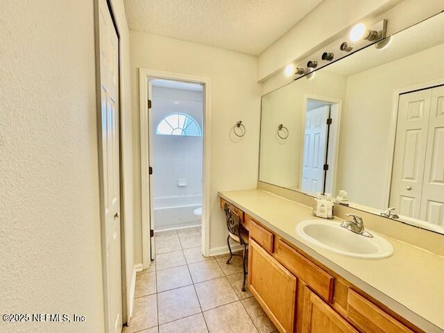 1810 Green Springs Cir Unit B, Fleming Island, FL 32003 - bathroom with vanity, tile patterned flooring, a textured ceiling, and a bathtub