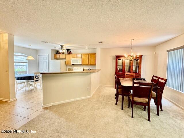 1810 Green Springs Cir Unit B, Fleming Island, FL 32003 - dining area featuring a textured ceiling, a chandelier, light colored carpet, and light tile patterned floors