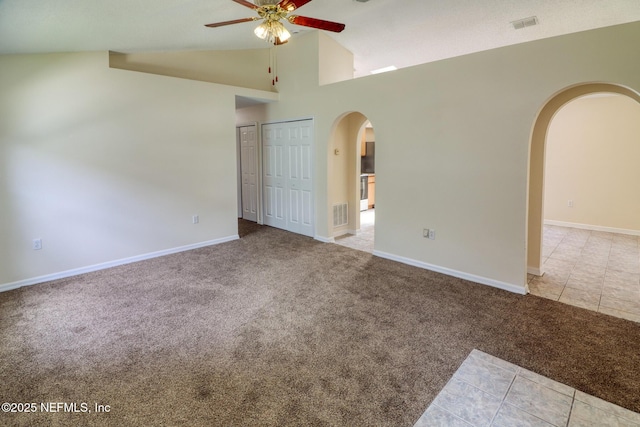 3371 Net Ct, Jacksonville, FL 32277 - tiled spare room featuring arched walkways, ceiling fan, carpet, and high vaulted ceiling