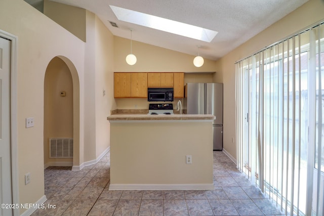 3371 Net Ct, Jacksonville, FL 32277 - kitchen featuring black microwave, a skylight, freestanding refrigerator, stove, and vaulted ceiling