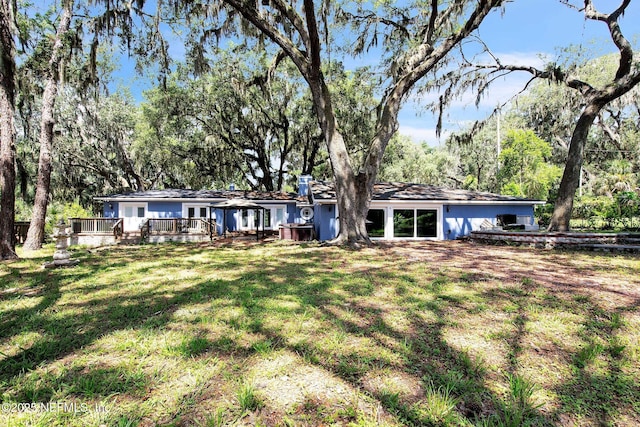 10268 Lake View Rd W, Jacksonville, FL 32225 - rear view of property with a wooden deck, a chimney, and a lawn