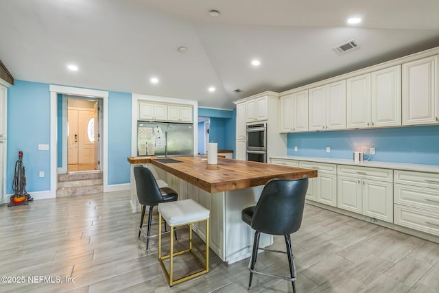 10268 Lake View Rd W, Jacksonville, FL 32225 - kitchen featuring wooden counters, appliances with stainless steel finishes, a kitchen breakfast bar, light wood-style flooring, and a center island