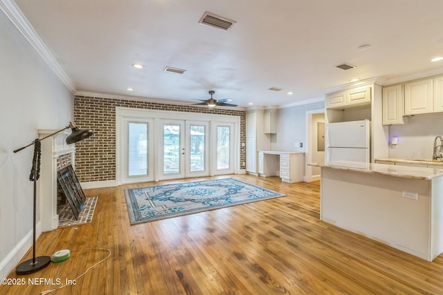 10268 Lake View Rd W, Jacksonville, FL 32225 - living room with ornamental molding, light wood-style flooring, ceiling fan, a brick fireplace, and brick wall