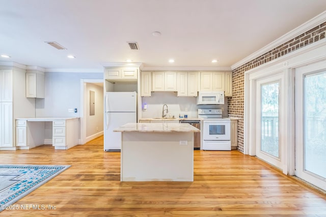 10268 Lake View Rd W, Jacksonville, FL 32225 - kitchen with white appliances, ornamental molding, light wood finished floors, a center island, and light stone counters