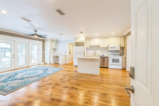 10268 Lake View Rd W, Jacksonville, FL 32225 - kitchen with white appliances, a kitchen island, light wood-style flooring, a ceiling fan, and light countertops