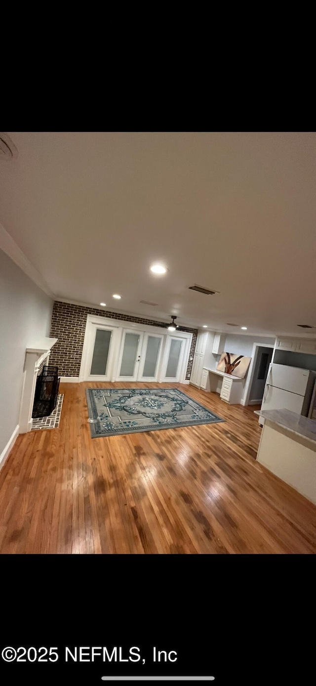 10268 Lake View Rd W, Jacksonville, FL 32225 - unfurnished living room with a fireplace with flush hearth, wood finished floors, and crown molding