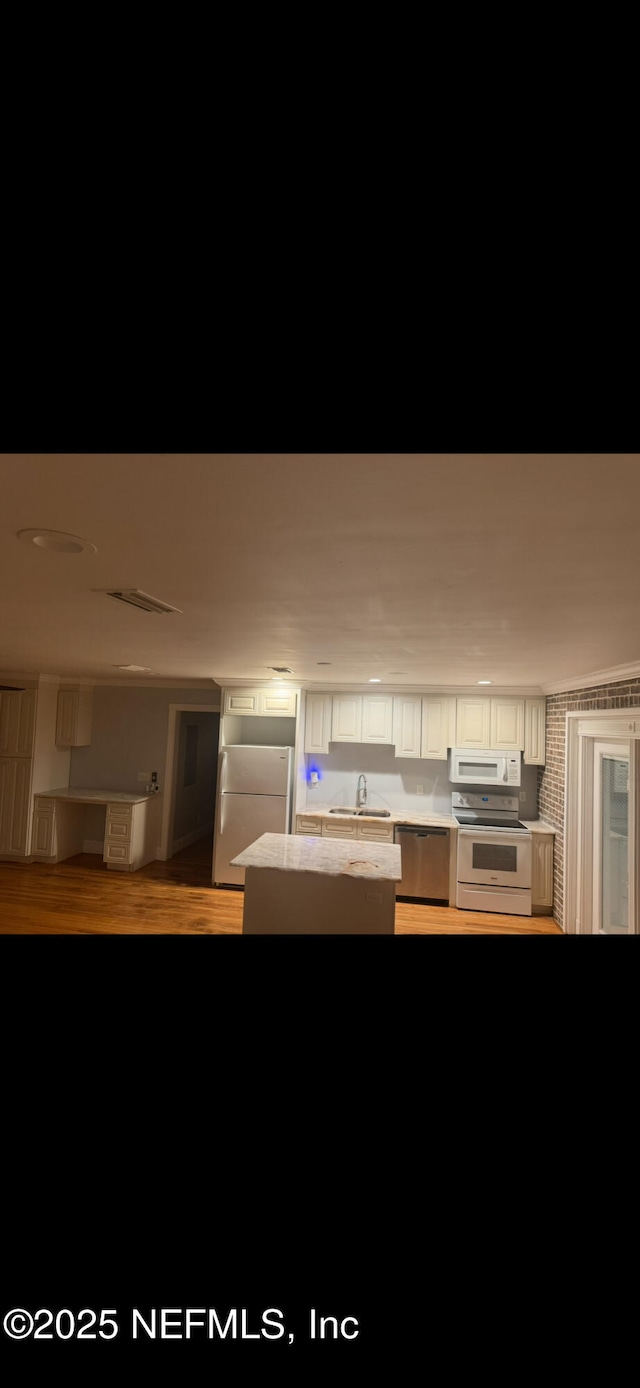 10268 Lake View Rd W, Jacksonville, FL 32225 - kitchen with white appliances, light countertops, white cabinetry, a kitchen island, and wood finished floors