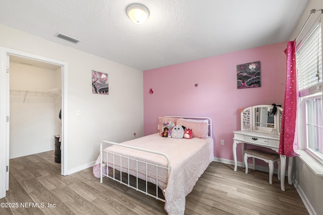 3299 Hidden Meadows Ct, Green Cove Springs, FL 32043 - bedroom with wood finished floors, a spacious closet, a textured ceiling, and a closet