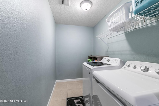 3299 Hidden Meadows Ct, Green Cove Springs, FL 32043 - washroom featuring washer and dryer, light tile patterned floors, a textured ceiling, and a textured wall