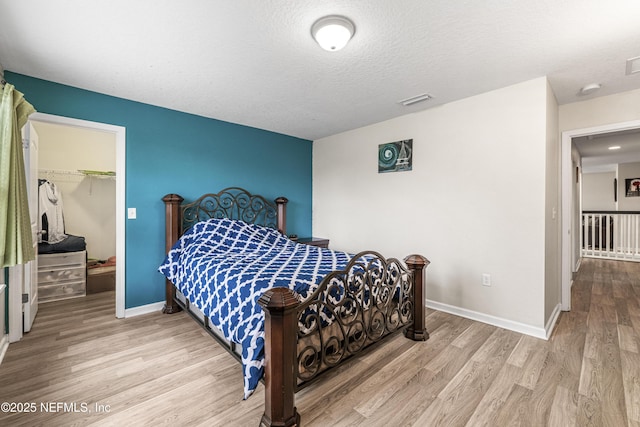 3299 Hidden Meadows Ct, Green Cove Springs, FL 32043 - bedroom featuring wood finished floors, a spacious closet, a closet, and a textured ceiling