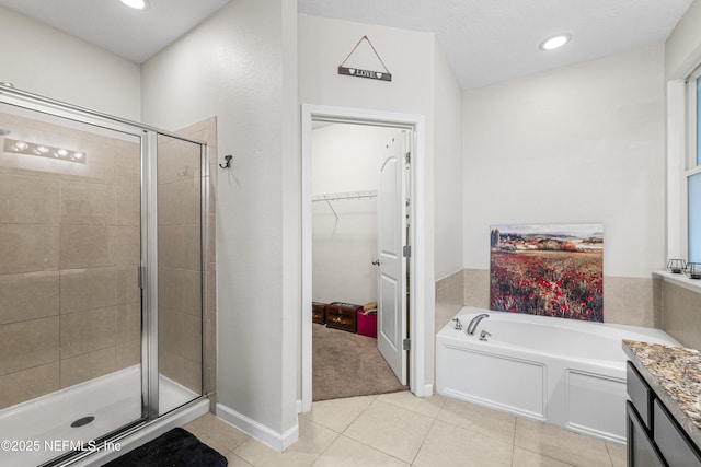 3299 Hidden Meadows Ct, Green Cove Springs, FL 32043 - bathroom featuring tile patterned flooring, a shower stall, a spacious closet, a bath, and vanity