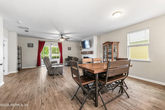 3299 Hidden Meadows Ct, Green Cove Springs, FL 32043 - dining space featuring light wood-style floors, ceiling fan, and a fireplace