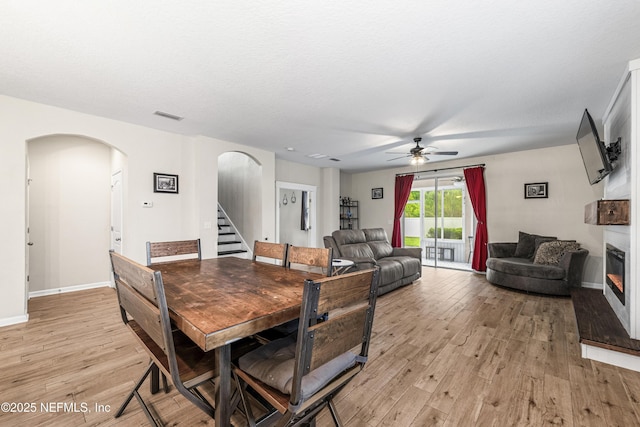3299 Hidden Meadows Ct, Green Cove Springs, FL 32043 - dining room featuring arched walkways, ceiling fan, light wood-type flooring, and stairs