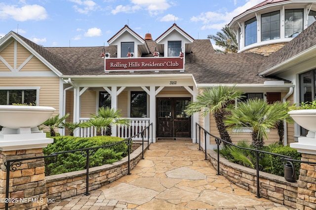 3299 Hidden Meadows Ct, Green Cove Springs, FL 32043 - view of exterior entry featuring roof with shingles, a chimney, and a porch