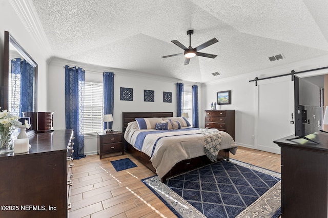 1565 Royal Fern Ln, Fleming Island, FL 32003 - bedroom with a textured ceiling, a barn door, multiple windows, crown molding, and light wood finished floors