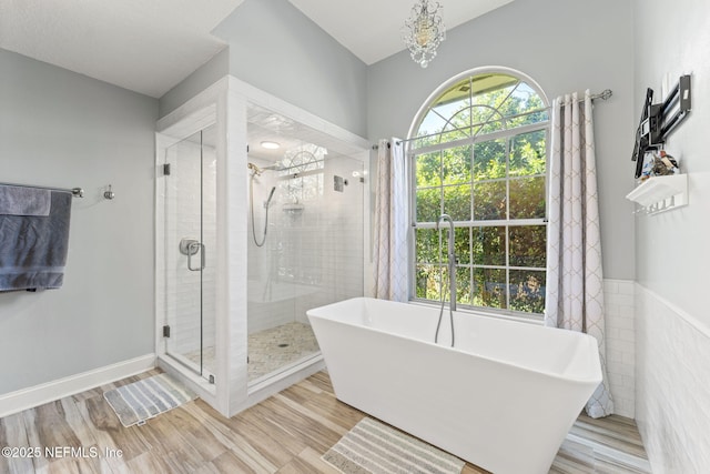 1565 Royal Fern Ln, Fleming Island, FL 32003 - full bath featuring a freestanding bath, a shower stall, a chandelier, wood finished floors, and wainscoting